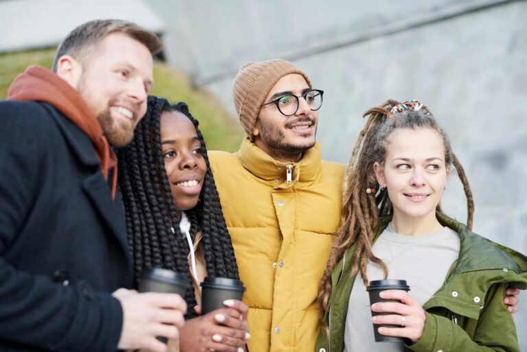 4 adults in winter clothes looking at a different camera. They each have a cup of coffee. For an article on ADHD and eaitng.
